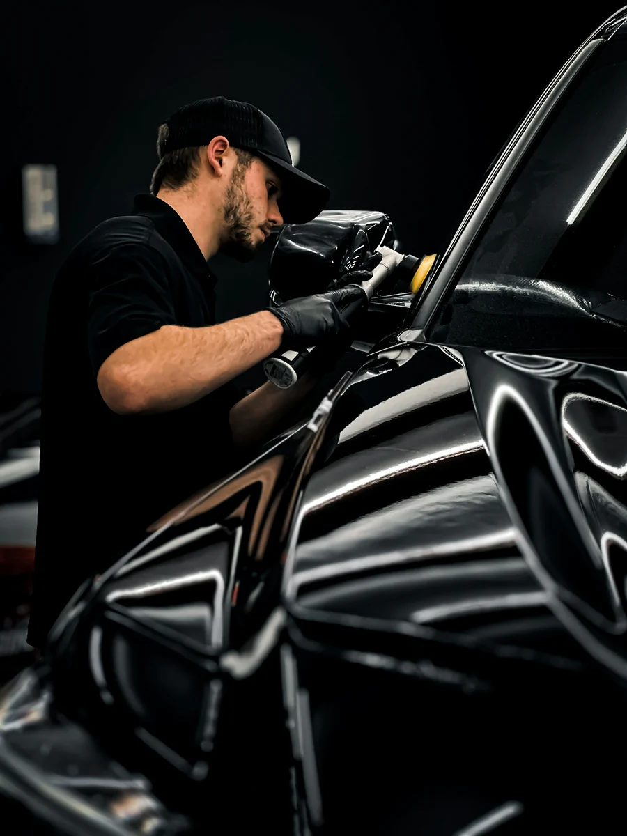 Detailer polishing a vehicle in the workshop